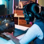 Shoulder,Shot,Of,Woman,With,Headphones,Playing,Online,Video,Game